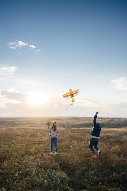 Un couple heureux fait voler un cerf-volant et passe du temps ensemble au grand air. Relation heureuse et vacances en famille.