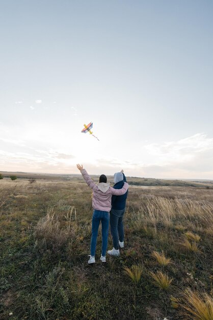 Un couple heureux fait voler un cerf-volant et passe du temps ensemble à l'extérieur dans une réserve naturelle Relations heureuses et vacances en famille Liberté et espace