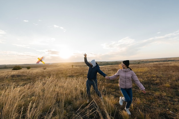 Un couple heureux fait voler un cerf-volant et passe du temps ensemble à l'extérieur dans une réserve naturelle Relations heureuses et vacances en famille Liberté et espace