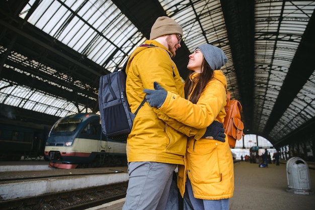 Couple heureux à la gare. se rencontrer après une longue période sans se voir