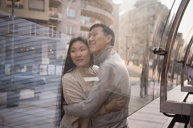 Un couple heureux de jeunes touristes asiatiques adultes se promènent dans la ville.