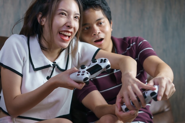 Photo couple heureux, jouer à des jeux de console, femme triche dans les jeux vidéo.