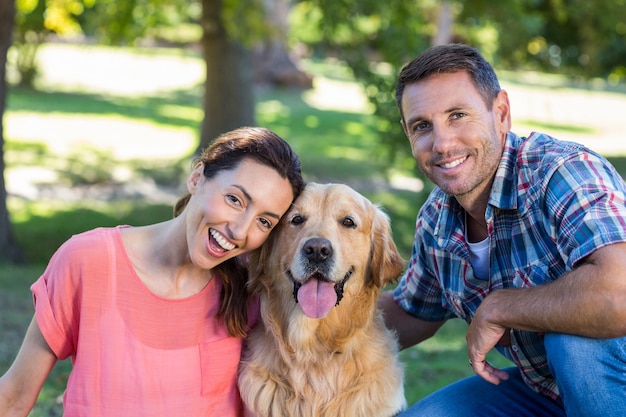 Couple heureux avec leur chien dans le parc