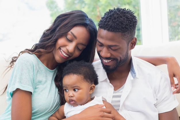 Couple heureux avec leur petite fille sur le canapé