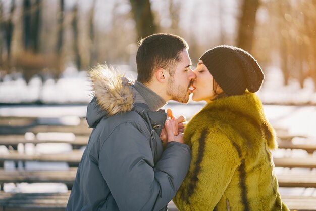 couple heureux marchant dans le parc sur une journée d&#39;hiver ensoleillée