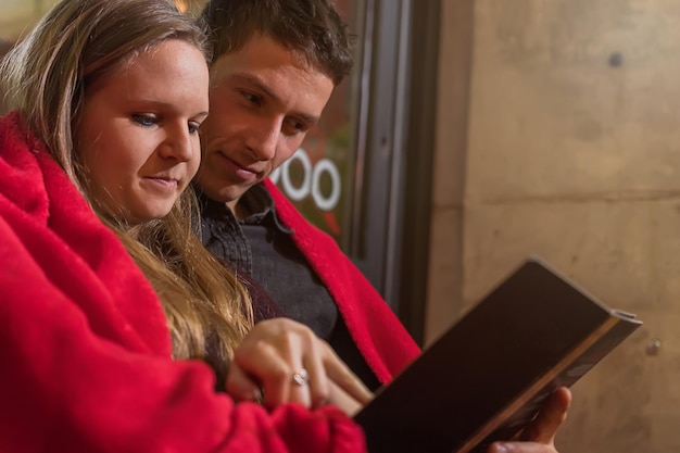 Couple heureux avec menu sur la terrasse du restaurant