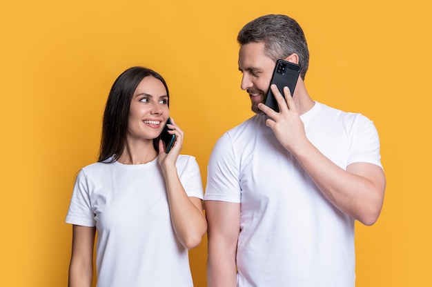 Couple heureux parlant sur un téléphone portable couple faisant un appel mobile en studio