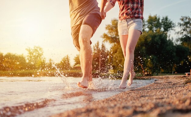 Couple Heureux Sur La Plage Exécuter Le Mouvement Jambes Coucher De Soleil éclaboussures D'eau