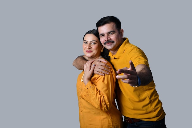 couple heureux portant des chemises jaunes étreignant le modèle pakistanais indien