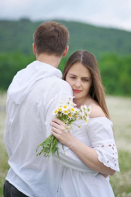 Couple heureux sur la prairie de camomille