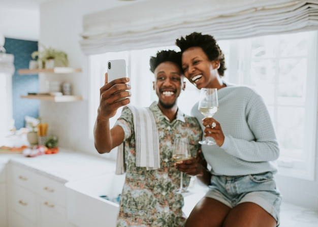 Couple heureux prenant un selfie dans la cuisine