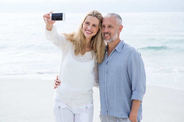 Couple heureux prenant selfie avec téléphone portable