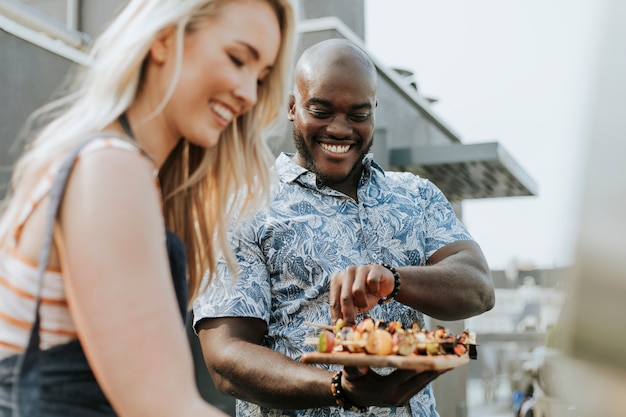 Couple heureux prépare des brochettes de barbecue