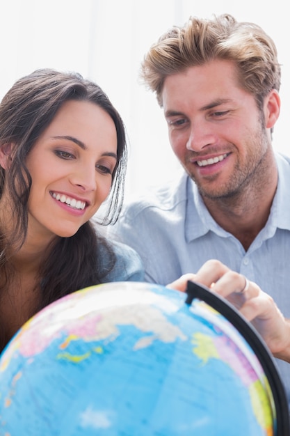 Couple heureux en regardant un globe