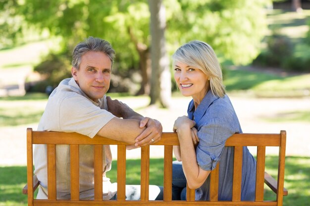 Couple heureux reposant sur le banc de parc