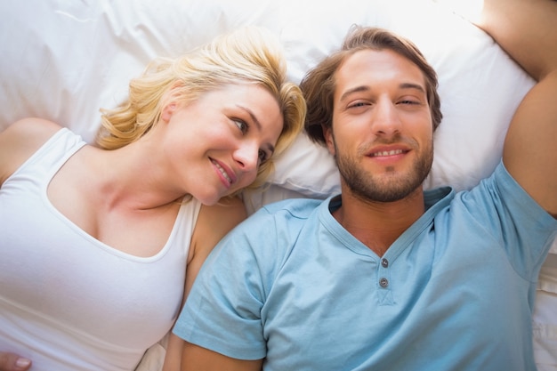 Couple heureux reposant sur le lit