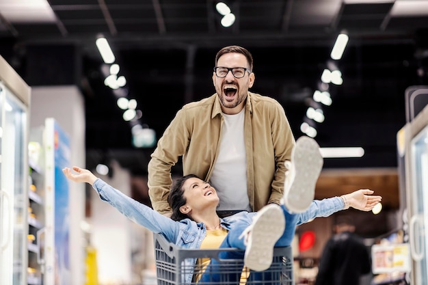 Un couple heureux s'amusant au supermarché