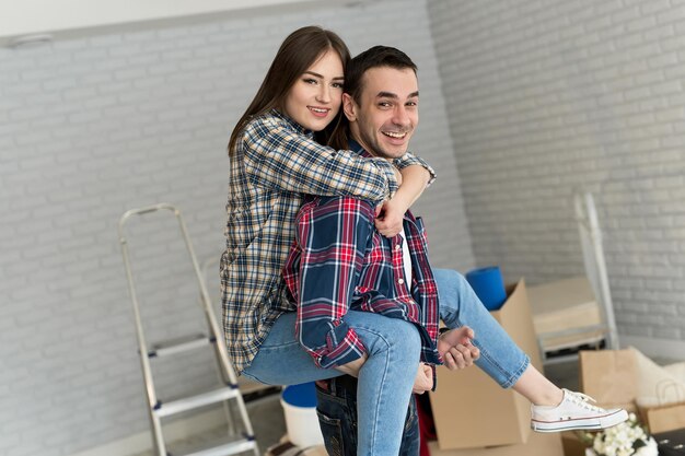 Un couple heureux s'amuse dans une nouvelle maison le jour du déménagement.