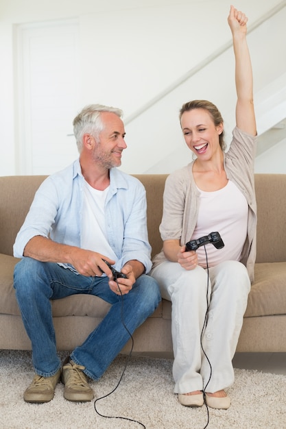 Couple heureux s&#39;amuser sur le canapé à jouer à des jeux vidéo