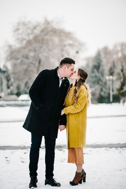 Couple heureux s'embrasse à l'extérieur en hiver.