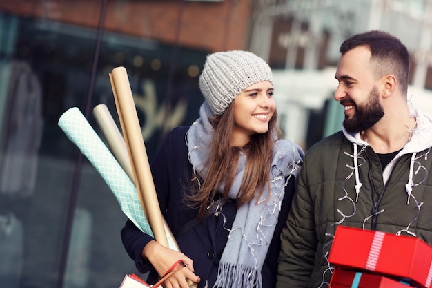 couple heureux avec des sacs à provisions après le shopping en ville souriant et s'embrassant