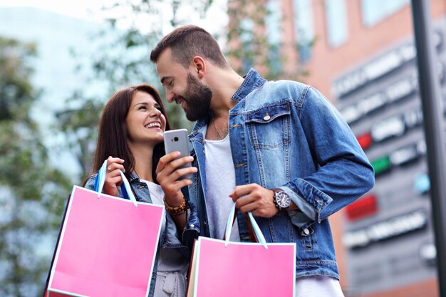 couple heureux avec des sacs à provisions après le shopping en ville