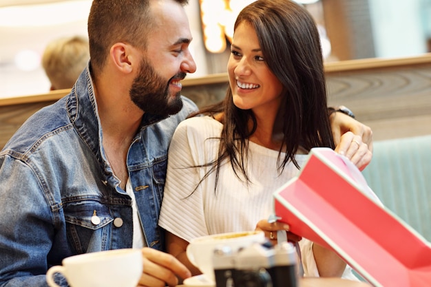 couple heureux avec des sacs à provisions au café