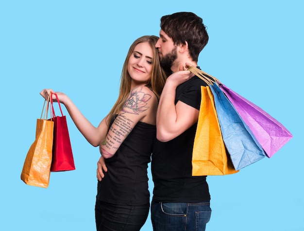 Couple heureux avec des sacs à provisions sur fond bleu