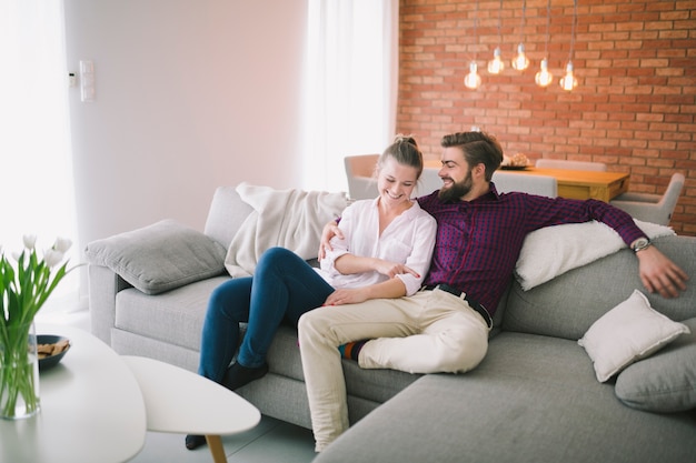 Photo couple heureux se détendre sur le canapé