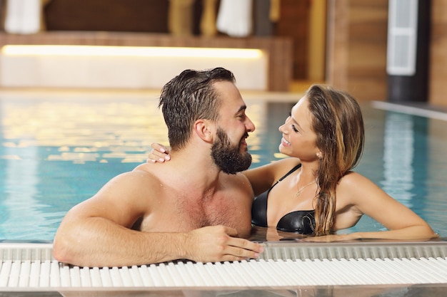 couple heureux se détendre dans le spa de la piscine