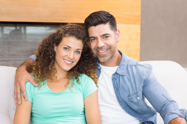 Couple heureux se détendre ensemble, souriant à la caméra