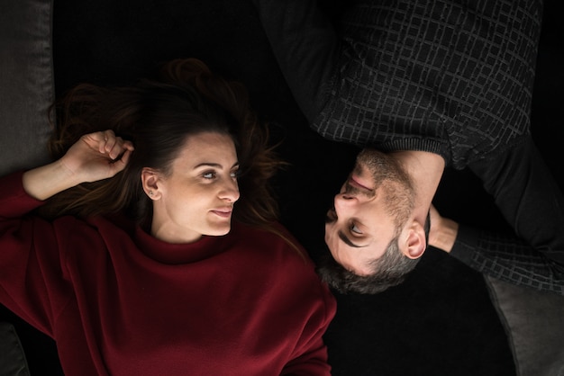 Couple heureux se détendre sur un tapis à la maison