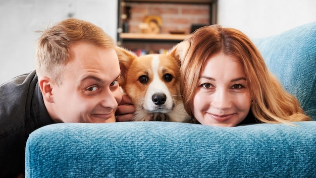 Couple heureux se reposant avec un chien sur un canapé