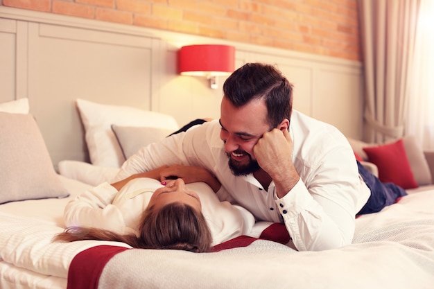 couple heureux se reposant dans la chambre d'hôtel