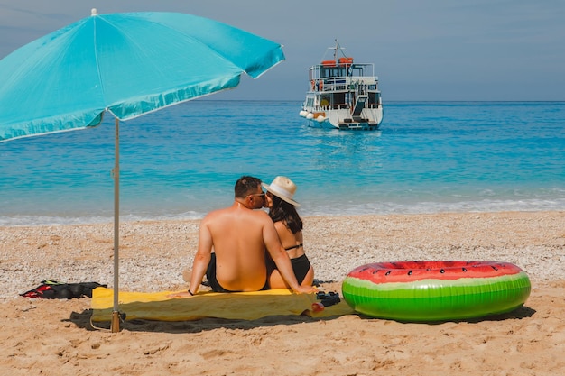 Couple heureux se reposant à la plage heureuse de Grèce