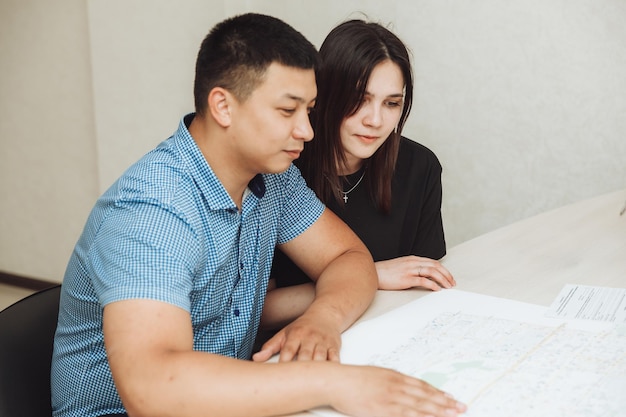 Un couple heureux signe un contrat ensemble au bureau un homme et une femme achètent un appartement et signent un contrat