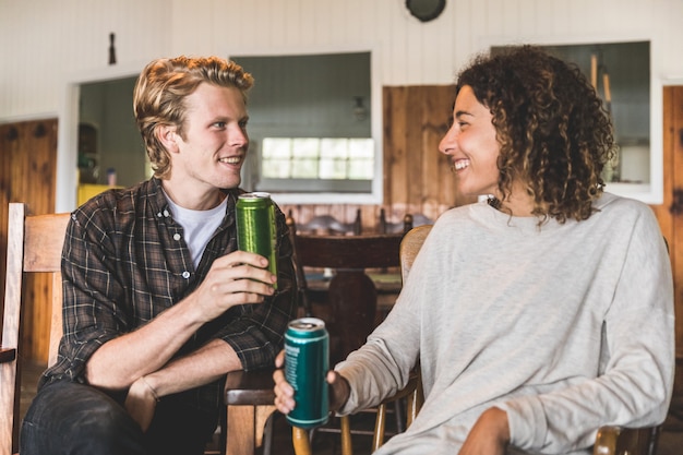 Couple heureux en sirotant un verre dans une cabane en bois au Canada