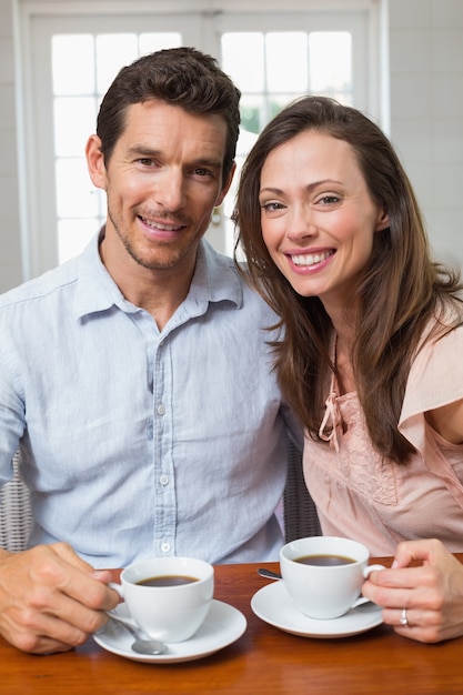 Couple heureux avec des tasses à café à la maison