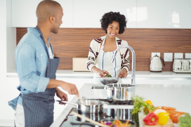 Couple heureux en train de préparer un repas dans la cuisine