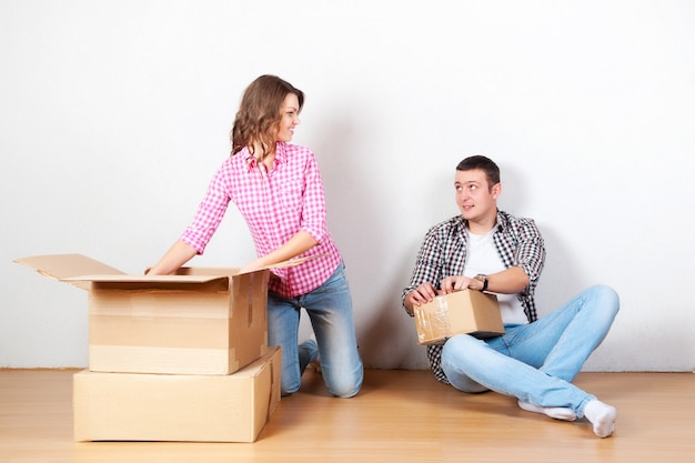 Couple heureux transportant des boîtes au déménagement.