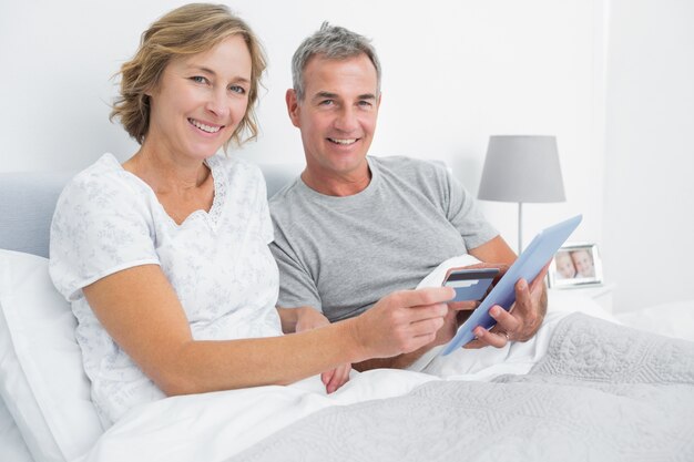 Couple heureux en utilisant leur tablet pc pour acheter en ligne