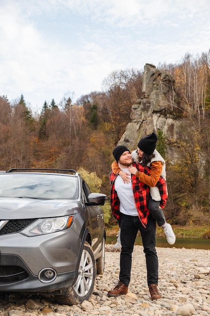 couple heureux voiture piggyback à la plage de la montagne rocheuse saison d'automne