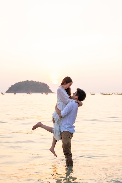 Couple heureux en voyage de noces sur la plage de sable tropicale en été