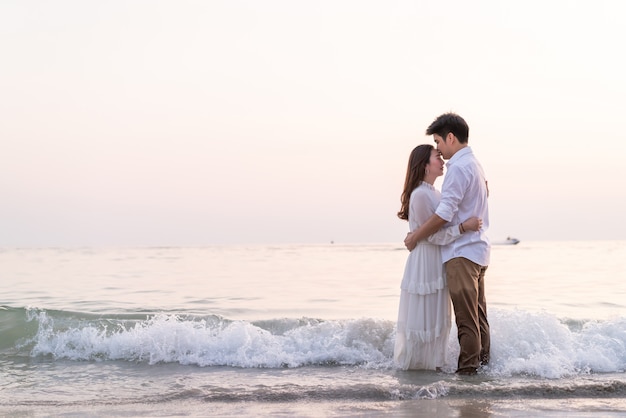 Couple heureux en voyage de noces sur la plage de sable tropicale en été