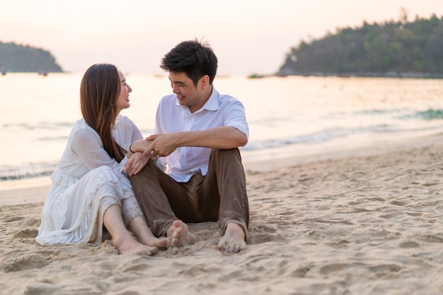 Couple heureux en voyage de noces sur la plage de sable tropicale en été