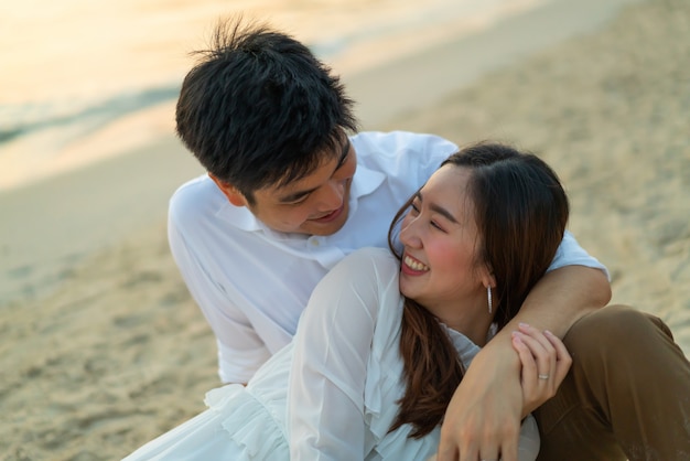 Couple heureux en voyage de noces sur la plage de sable tropicale en été