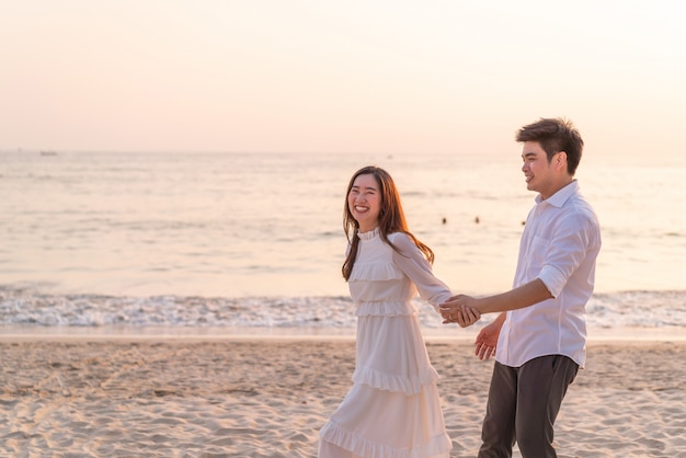 Couple heureux en voyage de noces sur la plage de sable tropicale en été