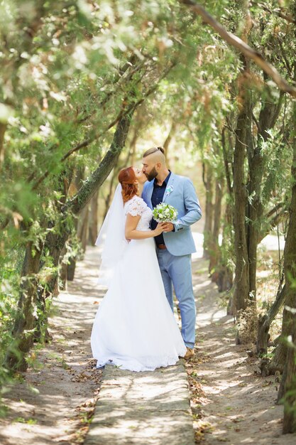 Couple de hipster amoureux juste marié en robe de mariée et costume dans le parc