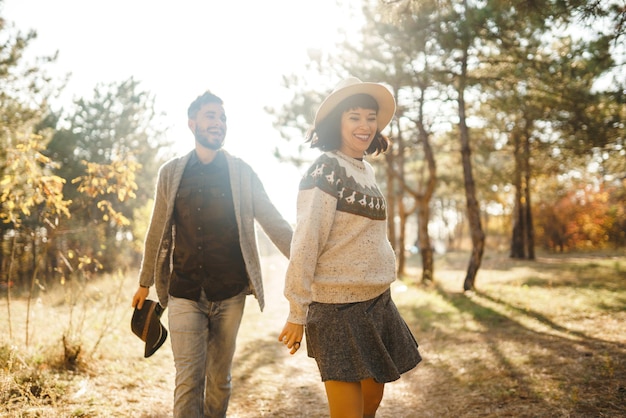 Un couple de hipsters qui se regardent, un couple qui porte de beaux chapeaux et des pulls.