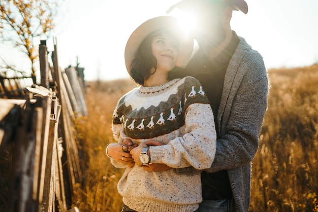 Un couple de hipsters qui se regardent, un couple qui porte de beaux chapeaux et des pulls.